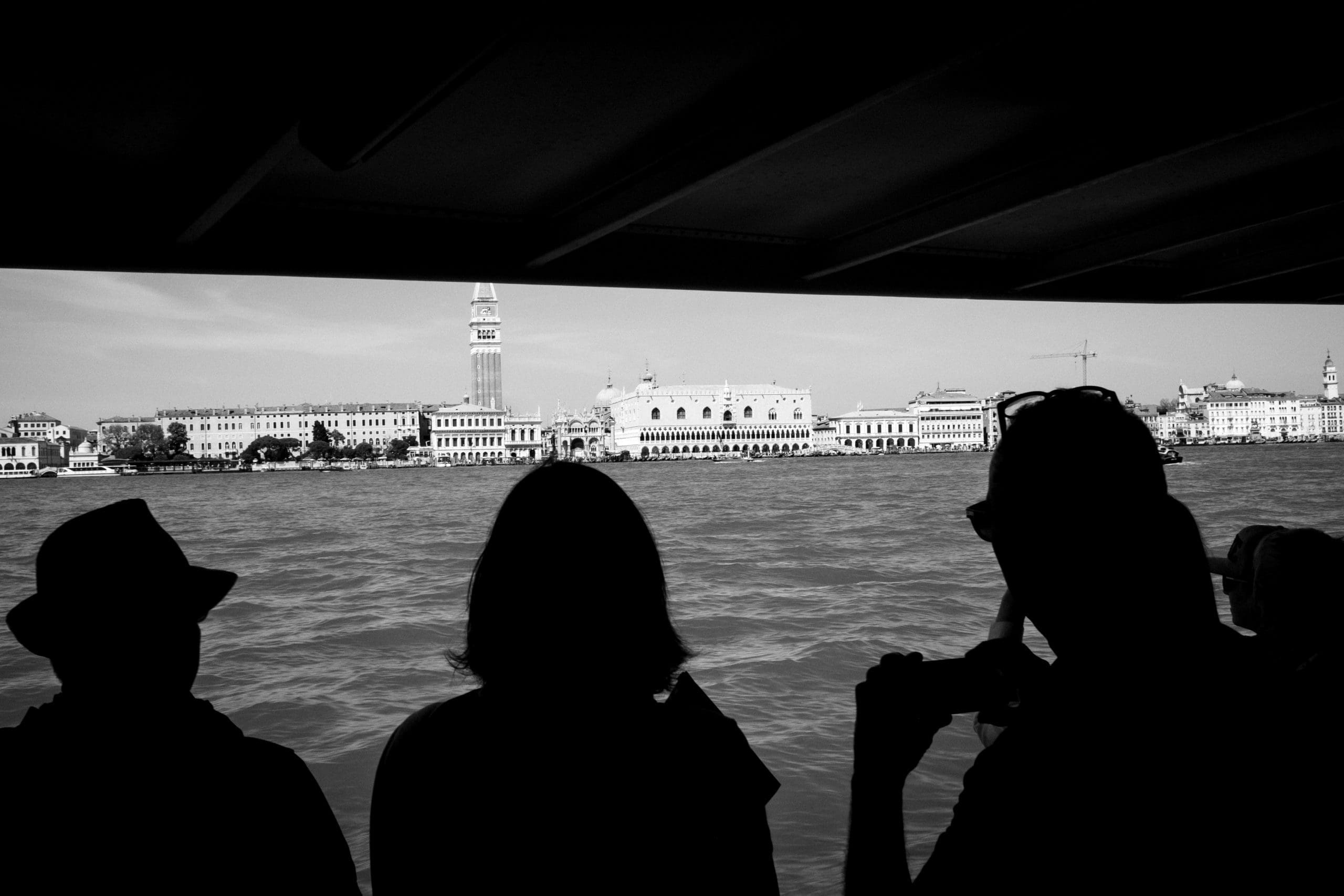 Silhouetten betrachten Venedigs Skyline vom Boot.