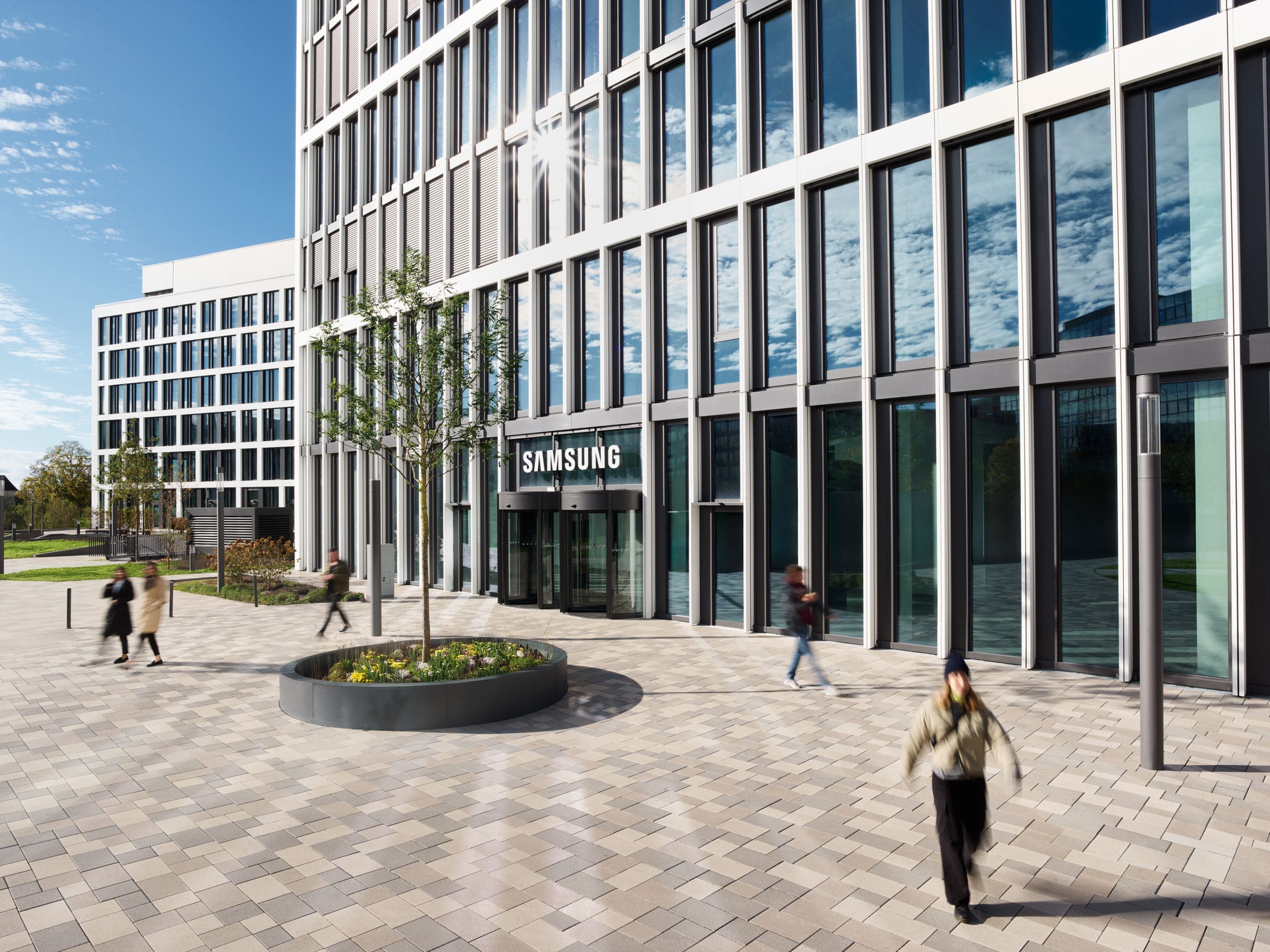 Modernes Bürogebäude mit Passanten draußen.